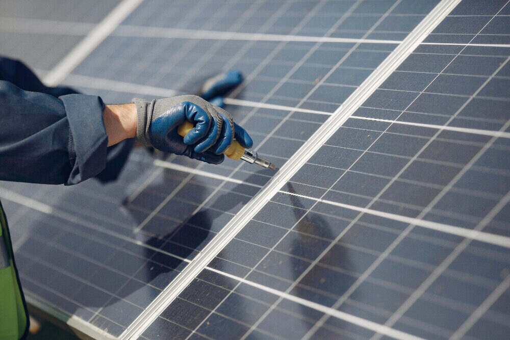 Solar technician inspecting a rooftop solar panel for common performance faults