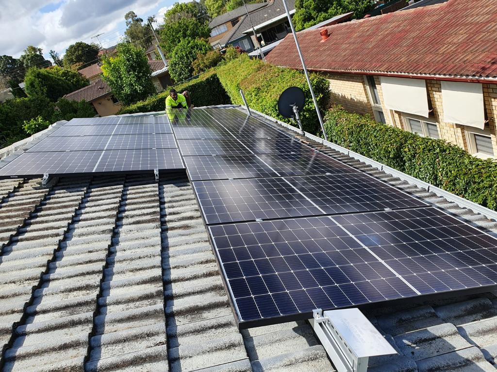 technician inspecting rooftop solar panels during 5 kW solar system installation